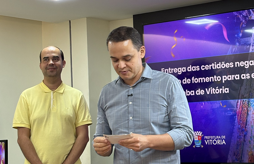 Prefeito Lorenzo Pazolini, na sala de reuniões, entregando a certidão negativa para os presidentes das escolas de samba de Vitória