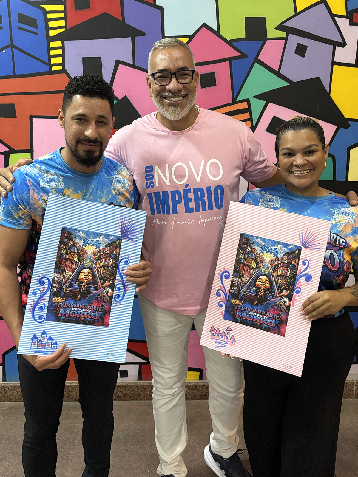 Weskley Blank e Alana Marques recebendo o figurino das mãos do carnavalesco Cahê Rodrigues